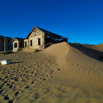 Verlassene Häuser in Kolmannskuppe mit hoher Sanddüne und Badwanne 