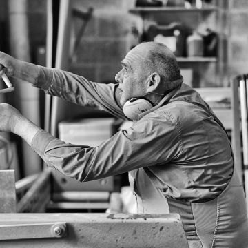 Behinderter repariert den Rolladen in der Holzwerkstatt