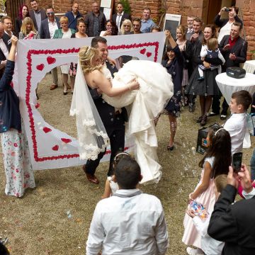 Bräutigam trägt Braut durch das ausgeschnittene Herz auf dem Kloster Limburg