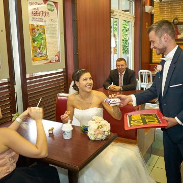 Bräutigam serviert seiner Braut einen Hamburger mit Pommes Frites im Mc Donald in Kaiserslautern