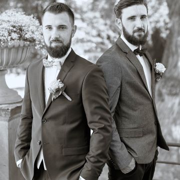 Bräutigam mit Bruder in schwarzweis in einer Männerpose