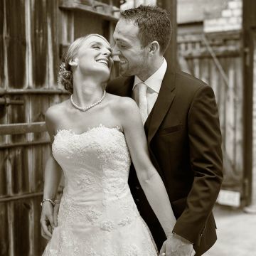 Brautpaar glücklich verliebt küsst sich in rustikaler Umgebung