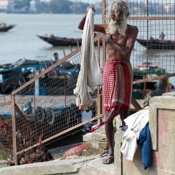 Hindu mit langem Bart wäscht Wäsche am Ganges