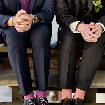 Bräutigam und Trauzeuge inbunten Socken auf der Treppe sitzend