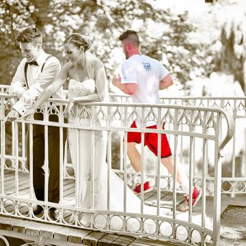Brautpaaar auf der Brücke im Schlosspark Herrnsheim mit Jogger