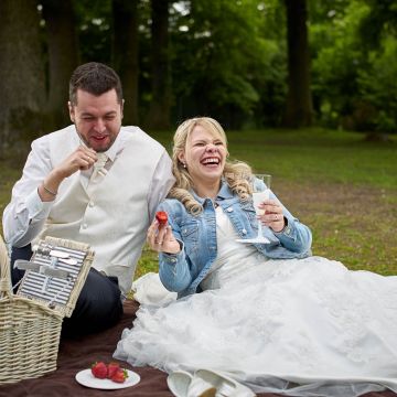 Brautpaar amüsiert sich beim Picknick auf der Wiese