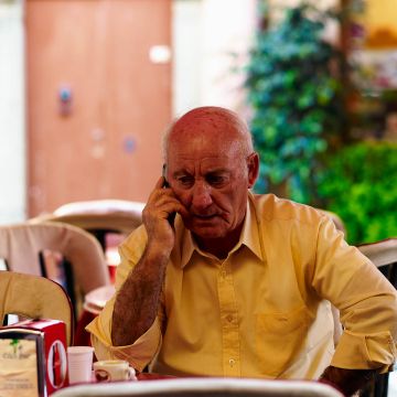 Italiener telefoniert mit dem Handy in einem Straßencafé